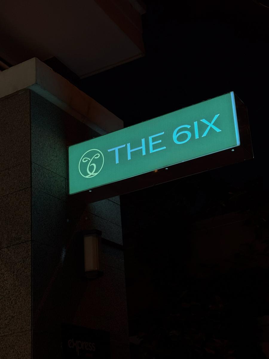 The 6ix lightbox sign outside the bar at night
